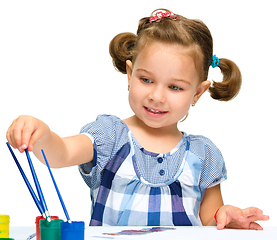 Image showing Little girl is painting with gouache