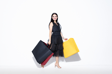 Image showing Young woman in dress shopping on white background