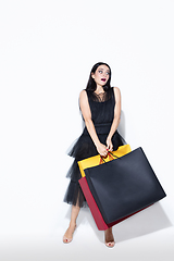 Image showing Young woman in dress shopping on white background