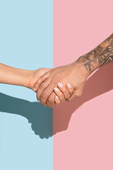 Image showing Closeup shot of human holding hands isolated on yellow studio background.