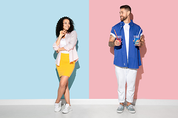 Image showing Young emotional man and woman on pink and blue background