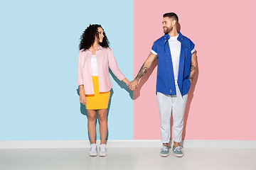 Image showing Young emotional man and woman on pink and blue background