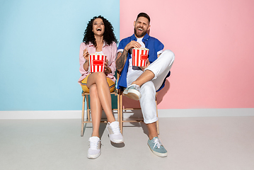 Image showing Young emotional man and woman on pink and blue background