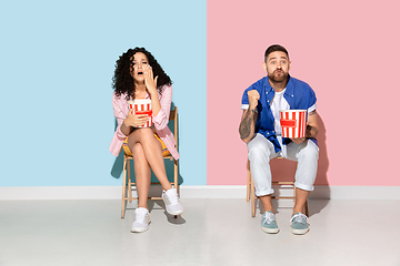 Image showing Young emotional man and woman on pink and blue background