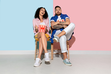 Image showing Young emotional man and woman on pink and blue background