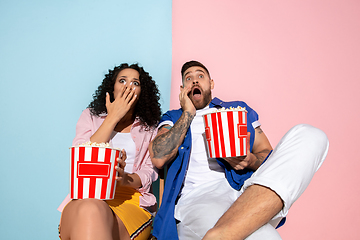 Image showing Young emotional man and woman on pink and blue background