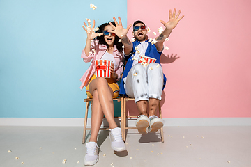 Image showing Young emotional man and woman on pink and blue background