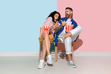 Image showing Young emotional man and woman on pink and blue background