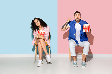 Image showing Young emotional man and woman on pink and blue background