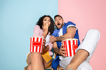 Image showing Young emotional man and woman on pink and blue background