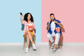 Image showing Young emotional man and woman on pink and blue background