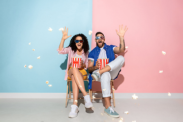 Image showing Young emotional man and woman on pink and blue background