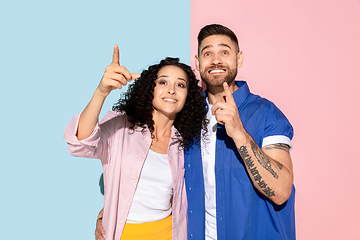 Image showing Young emotional man and woman on pink and blue background