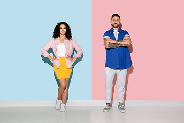 Image showing Young emotional man and woman on pink and blue background