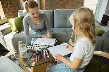 Image showing Teacher and little girl, or mom and daughter. Homeschooling concept