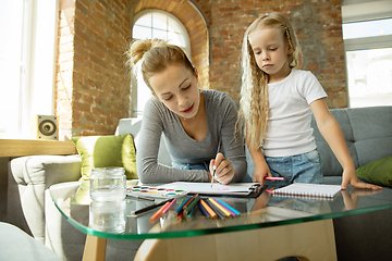 Image showing Teacher and little girl, or mom and daughter. Homeschooling concept