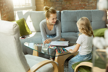 Image showing Teacher and little girl, or mom and daughter. Homeschooling concept