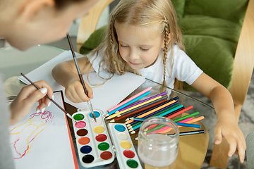 Image showing Teacher and little girl, or mom and daughter. Homeschooling concept