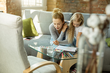 Image showing Teacher and little girl, or mom and daughter. Homeschooling concept