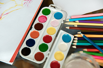 Image showing Used water-color paint-box, brush, pencils and pastels on wooden with paper