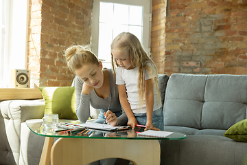 Image showing Teacher and little girl, or mom and daughter. Homeschooling concept