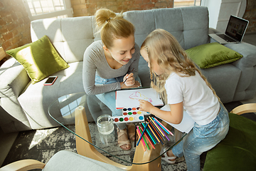 Image showing Teacher and little girl, or mom and daughter. Homeschooling concept
