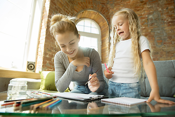 Image showing Teacher and little girl, or mom and daughter. Homeschooling concept