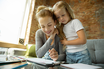 Image showing Teacher and little girl, or mom and daughter. Homeschooling concept