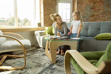 Image showing Teacher and little girl, or mom and daughter. Homeschooling concept