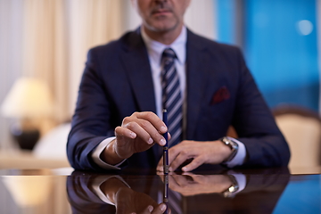 Image showing corporate businessman at luxury office pen holding 