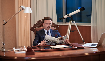 Image showing corporate business man at office reading magazine