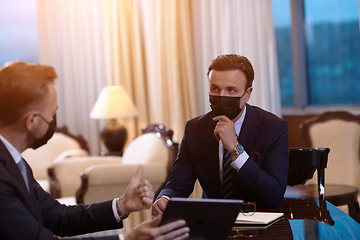 Image showing business people wearing crona virus protection face mask on meeting