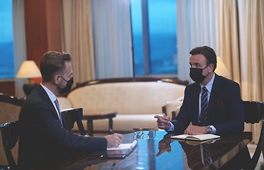 Image showing business people wearing crona virus protection face mask on meeting