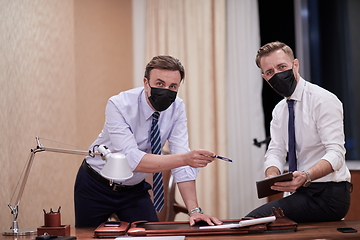 Image showing business people wearing crona virus protection face mask on meeting