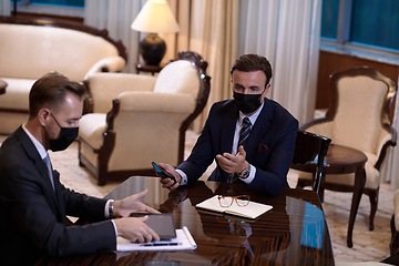 Image showing business people wearing crona virus protection face mask on meeting