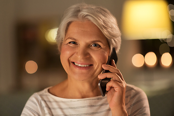 Image showing old woman calling on smartphone at home in evening