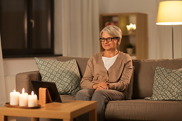 Image showing happy senior woman with tablet pc at home at night