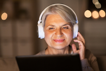 Image showing senior woman in headphones listening to music