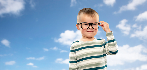 Image showing portrait of smiling boy in glasses over blue sky