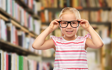 Image showing smiling little girl in black glasses at library