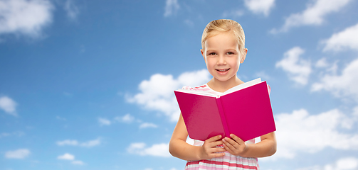 Image showing smiling little girl reading book