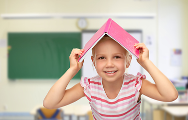 Image showing little girl of book on top of her head at school