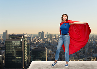 Image showing happy woman in red superhero cape over tokyo city