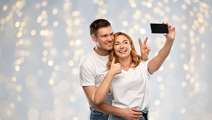 Image showing happy couple in white t-shirts taking selfie