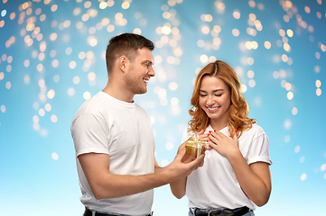 Image showing happy couple in white t-shirts with christmas gift