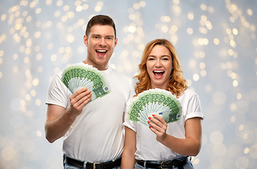 Image showing happy couple in white t-shirts with euro money