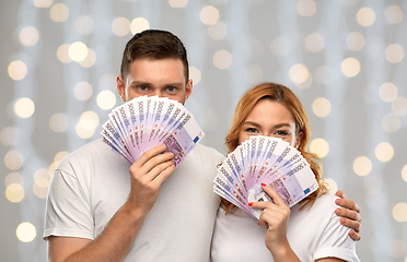 Image showing happy couple in white t-shirts with euro money