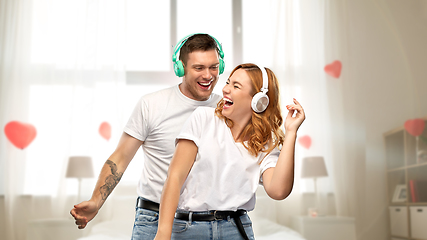 Image showing happy couple in headphones dancing