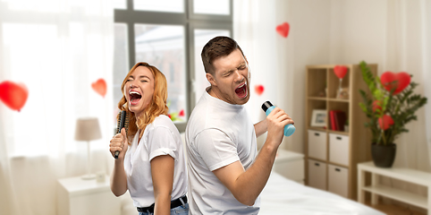 Image showing couple singing to hairbrush and lotion at home