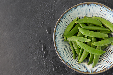 Image showing peas in bowl on wet slate stone background